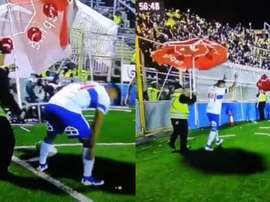 Le llovían objetos desde la grada... ¡y le ayudaron a pararlos con una sombrilla! Captura/TigoSports